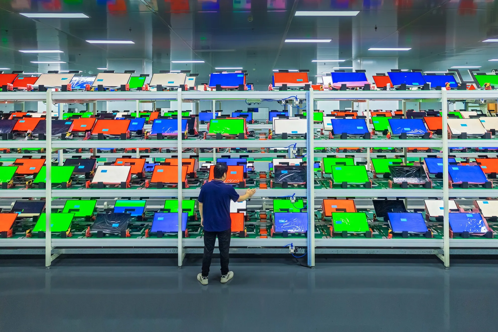 Worker inspecting electronics on a factory production line