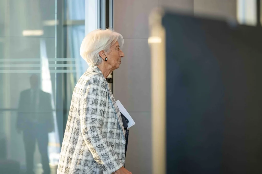 Christine Lagarde walking in profile while carrying documents