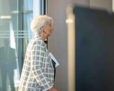 Christine Lagarde walking in profile while carrying documents