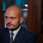 Czech billionaire Michal Strnad in a pinstripe suit looking to the side