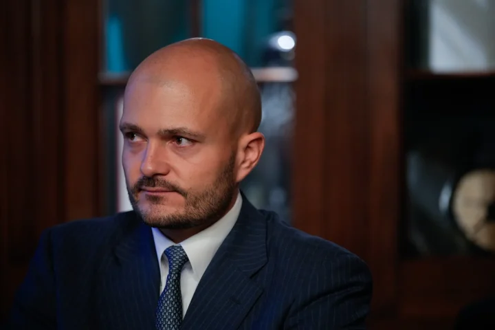 Czech billionaire Michal Strnad in a pinstripe suit looking to the side