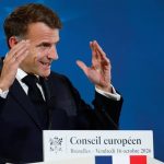 French President Emmanuel Macron gestures while speaking at a European Council press conference