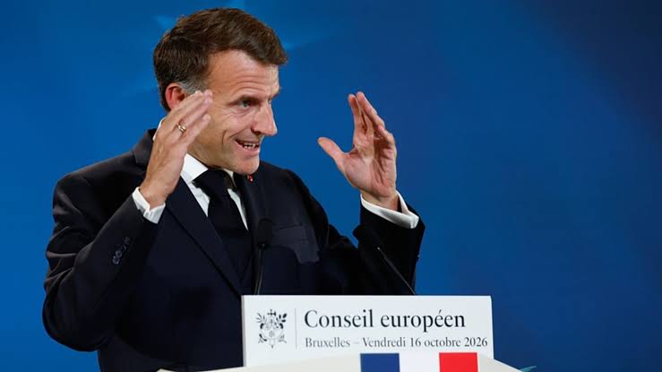 French President Emmanuel Macron gestures while speaking at a European Council press conference