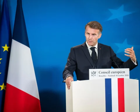 French President Emmanuel Macron gesturing while speaking at a podium