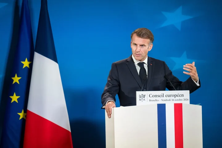 French President Emmanuel Macron gesturing while speaking at a podium