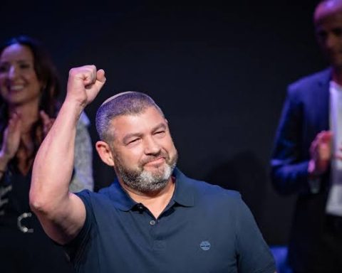 Ofer Winter raising his fist on stage at a rally