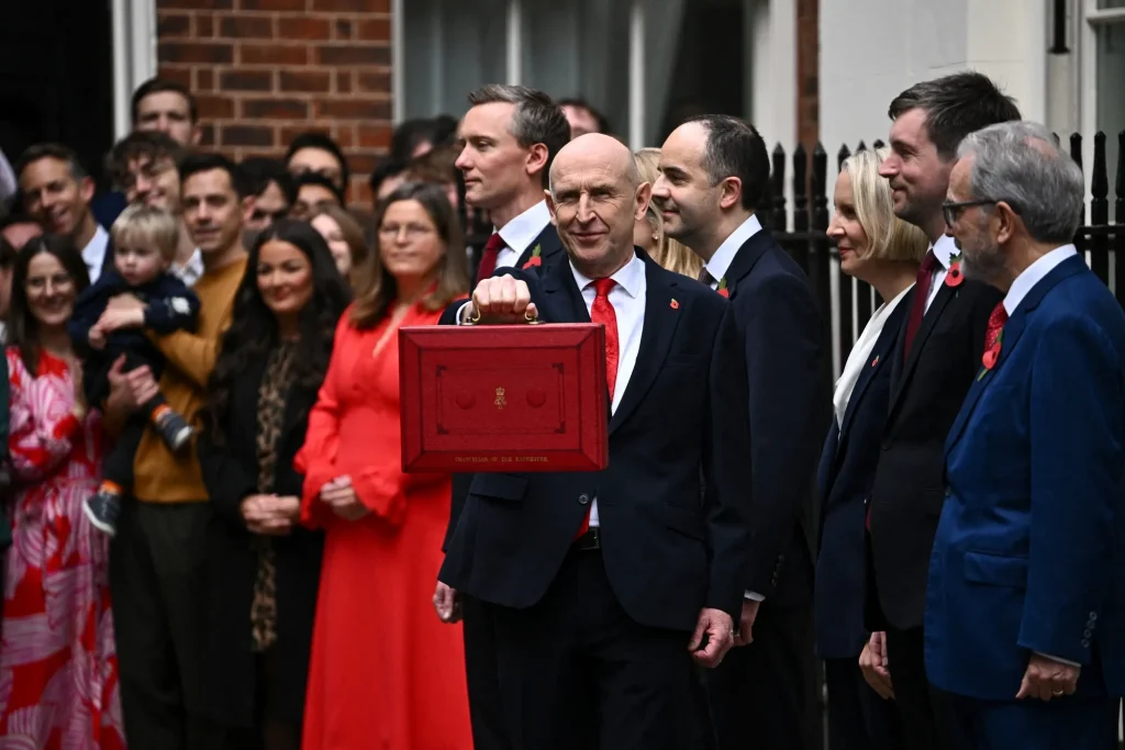 UK Chancellor holding up the red budget box outside Downing Street