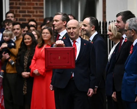 UK Chancellor holding up the red budget box outside Downing Street
