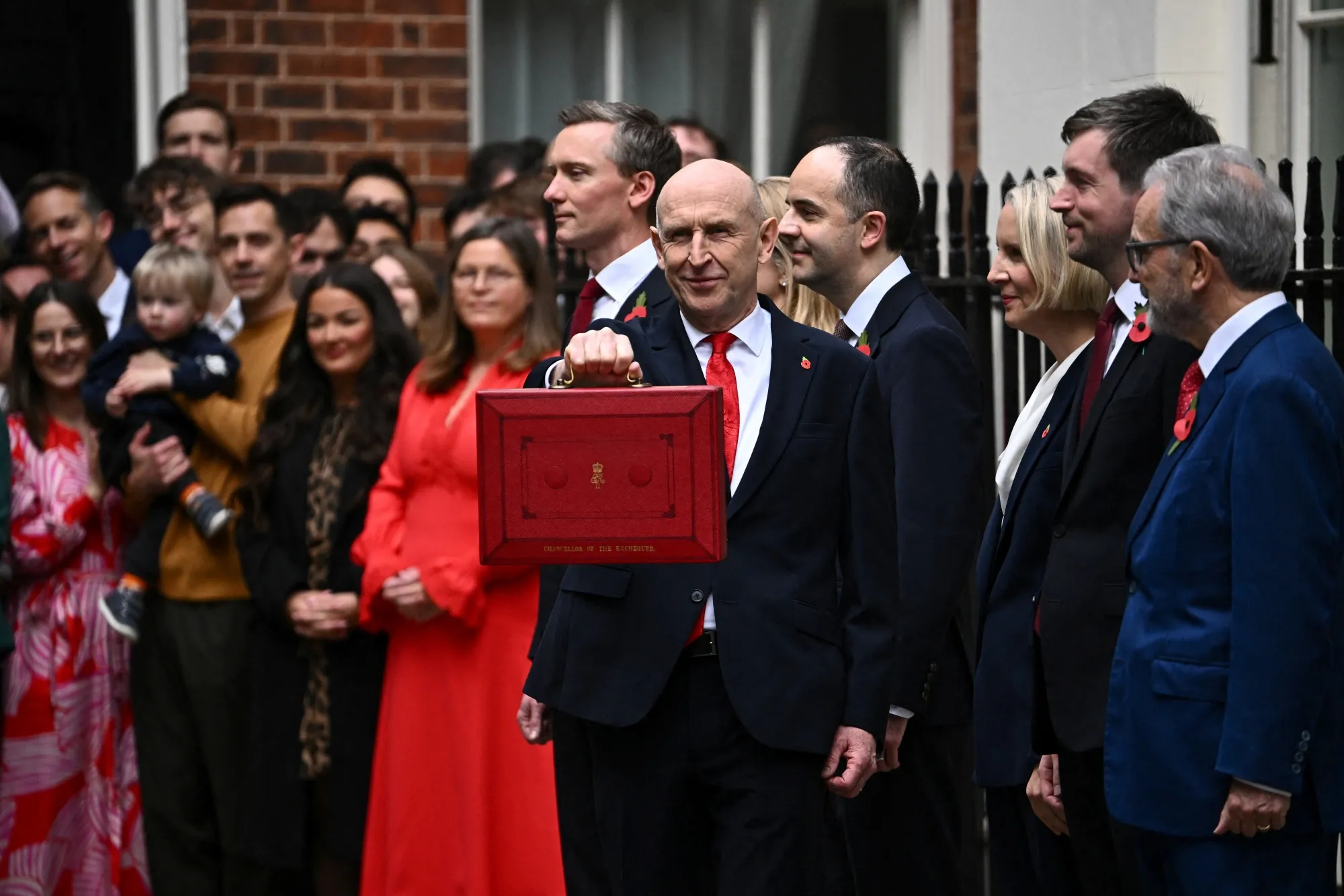 UK Chancellor holding up the red budget box outside Downing Street