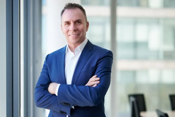 Wizz Air CEO Jozsef Varadi standing with arms crossed in an office